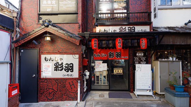店舗前の歩道から見た建物外観と入口、近くの通りの様子がわかる引きの写真