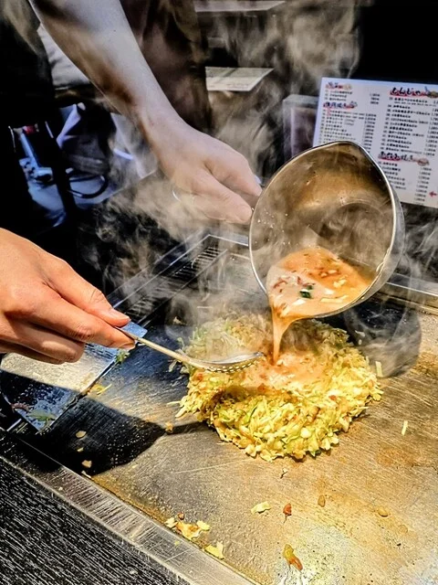 もんじゃ、お好み焼き、ドリンク、小皿が並んだ二人分の卓上全景